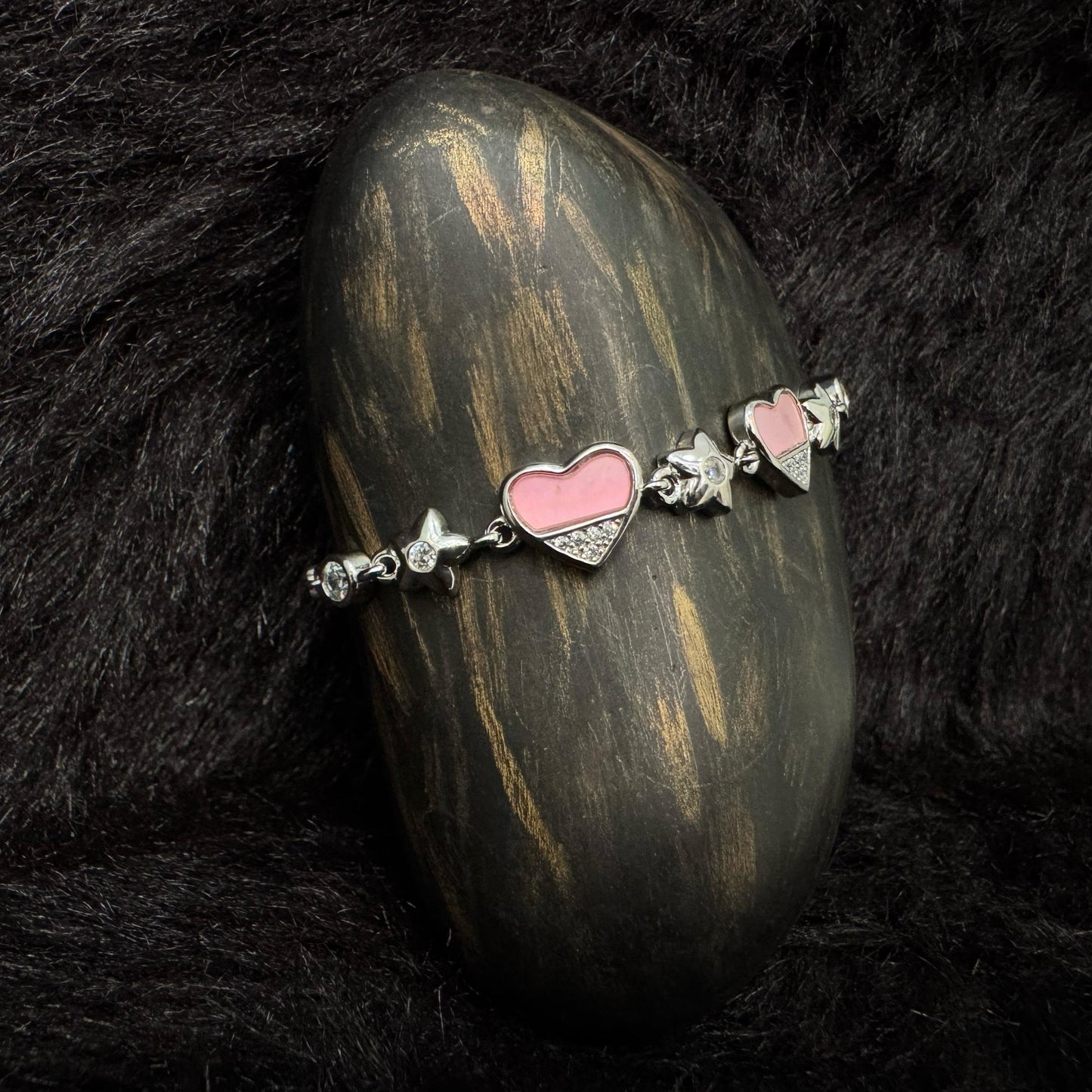 Sterling silver bracelet with pink enamel heart charms and zircon-studded details
