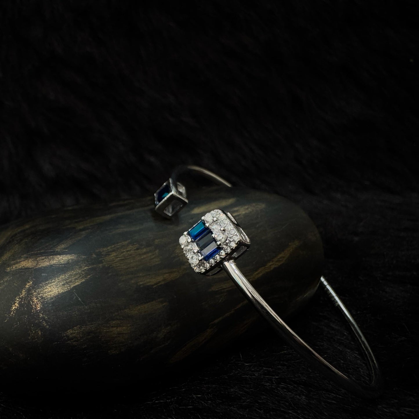Sterling silver open cuff bracelet with rectangular and square deep blue stones set in zircon-studded and bezel settings