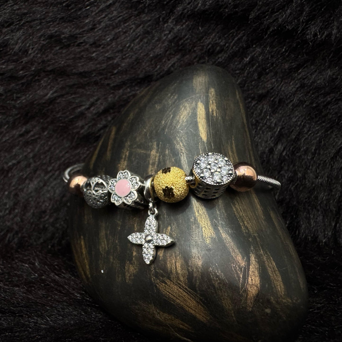 Sterling silver charm bracelet with floral, star, and mixed metal beads featuring zircon and enamel details