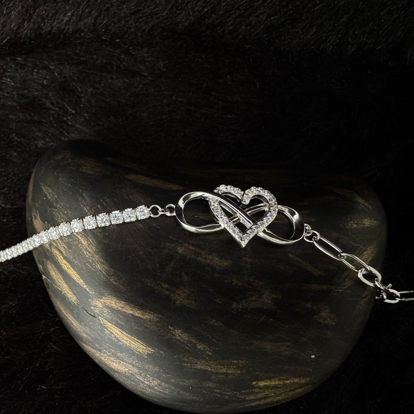 Sterling silver bracelet with a zircon-studded infinity and heart centerpiece, and adjustable chain closure