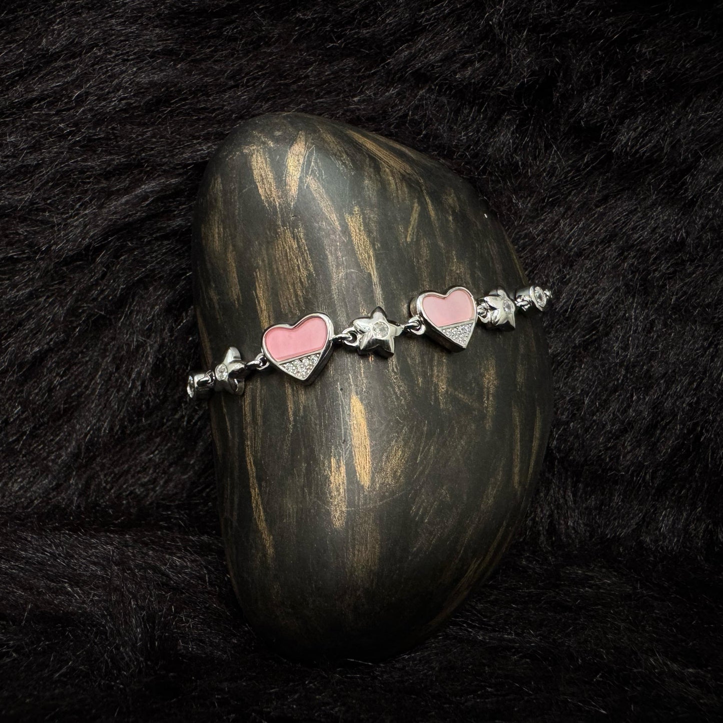 Sterling silver bracelet with pink enamel heart charms and zircon-studded details