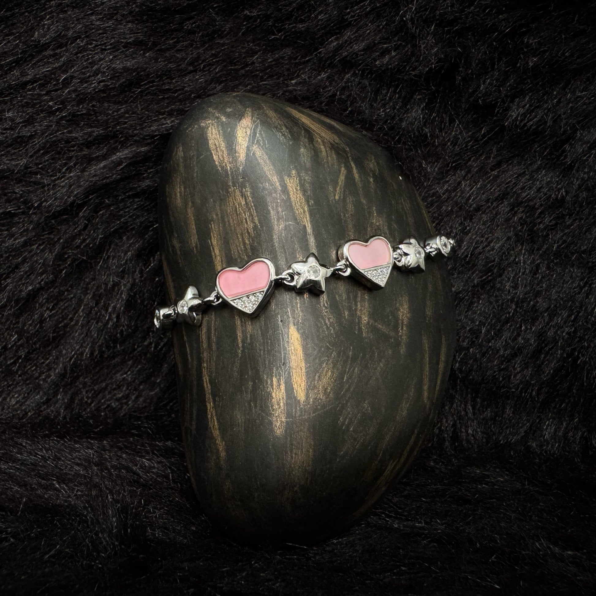 Sterling silver bracelet with pink enamel heart charms and zircon-studded details