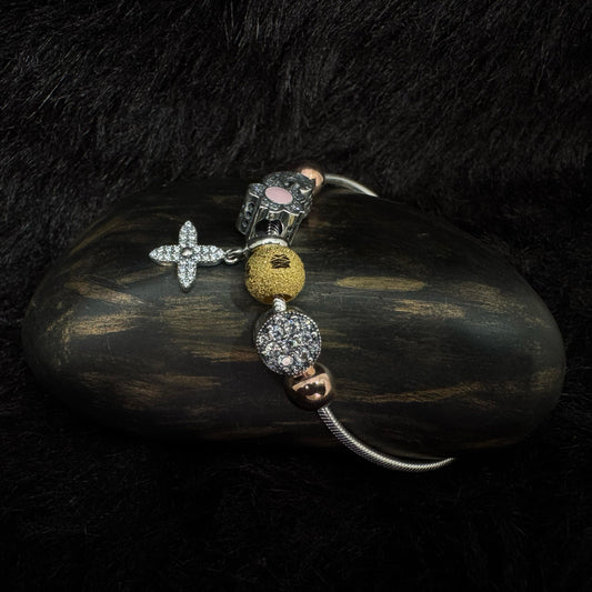 Sterling silver charm bracelet with floral, star, and mixed metal beads featuring zircon and enamel details