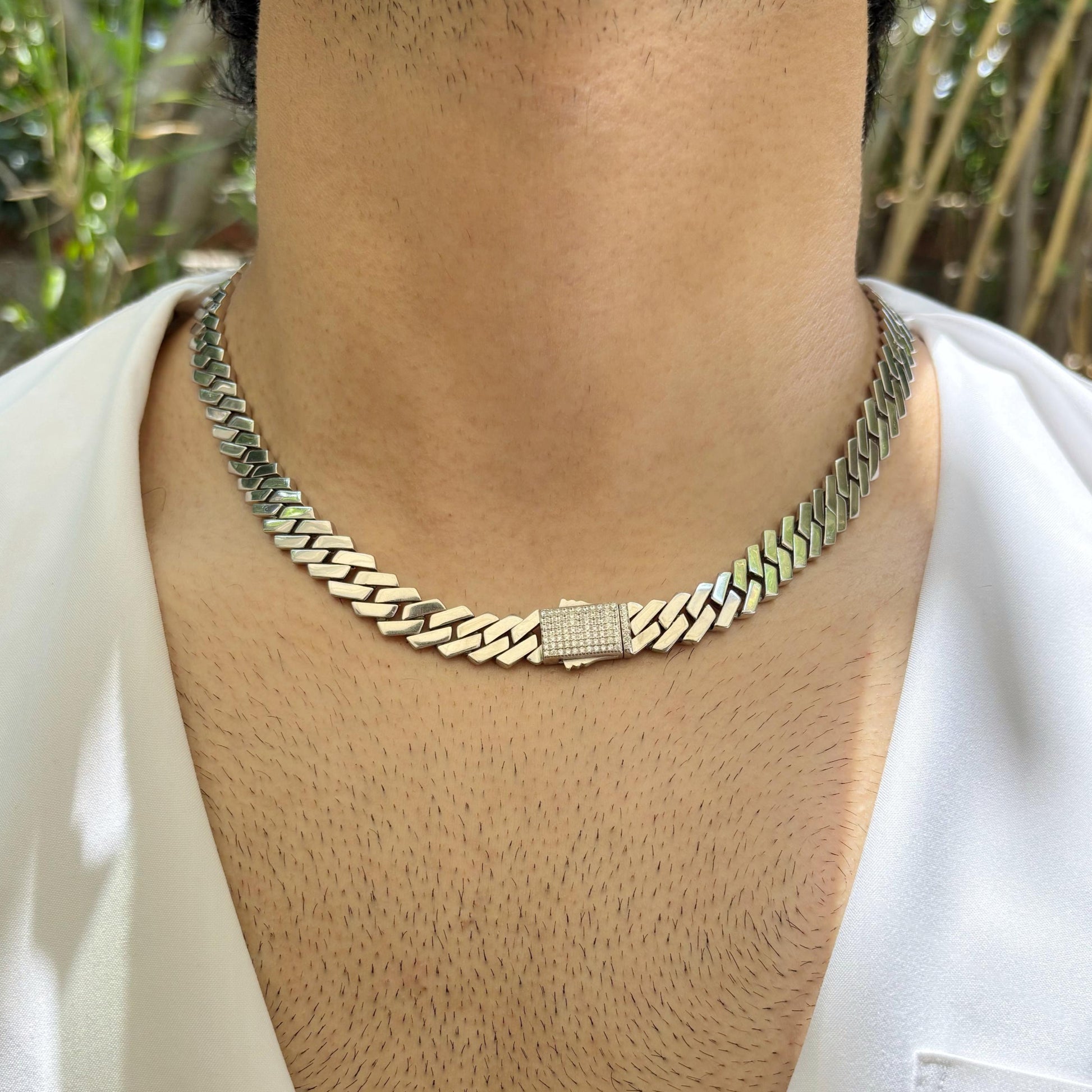 Clasp of a sleek and polished Cuban link sterling silver chain worn around the neck, showcasing its elegant and timeless design.
