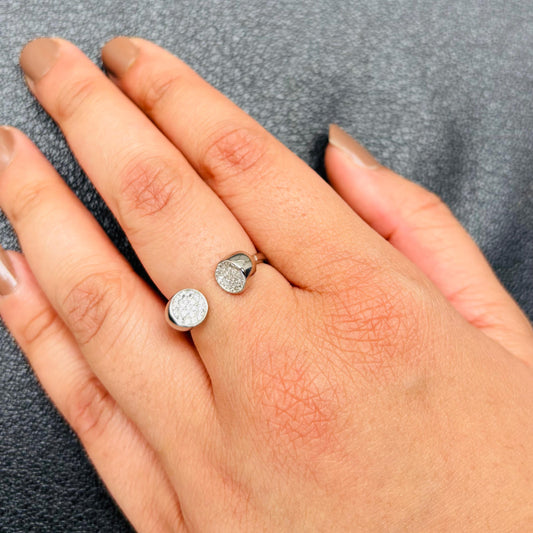 A delicate sterling silver adjustable ring featuring two charm motifs—one polished and the other adorned with sparkling CZ stones.