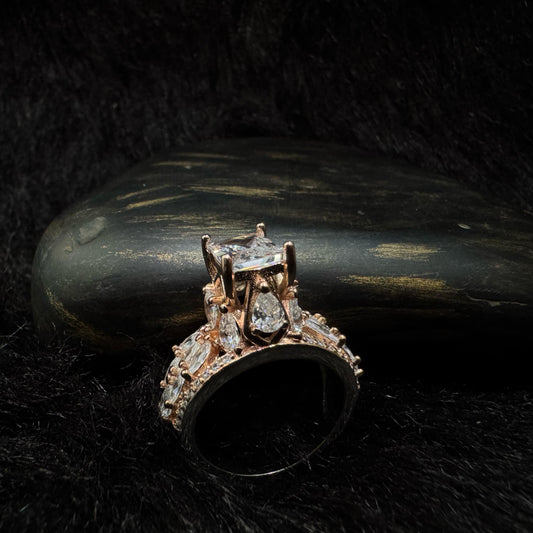 Elegant rose gold-plated 925 silver ring with a raised radiant-cut center stone and teardrop zirconia accents.