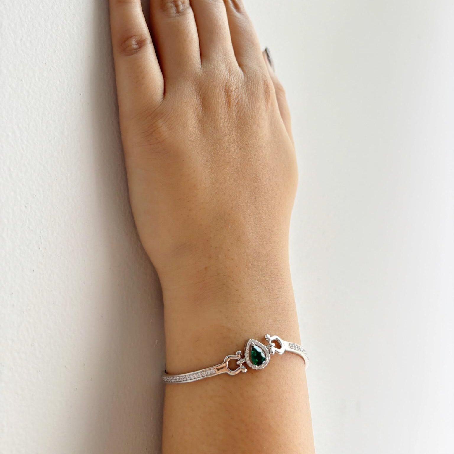 A925 sterling silver bracelet featuring a teardrop-shaped emerald-green stone surrounded by a halo of zircon accents.