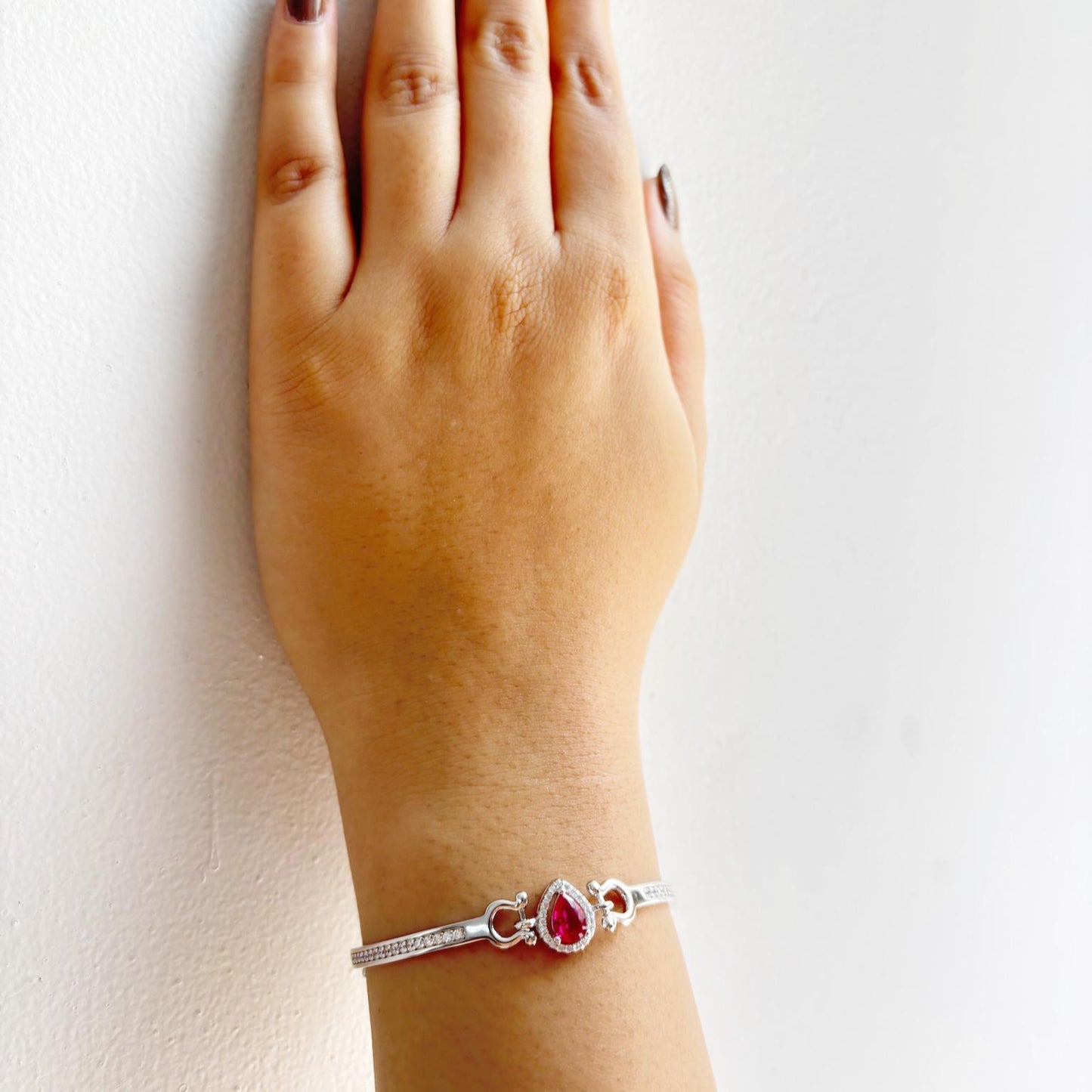 A 925 sterling silver bracelet featuring a teardrop-shaped emerald-pink stone surrounded by a halo of zircon accents.