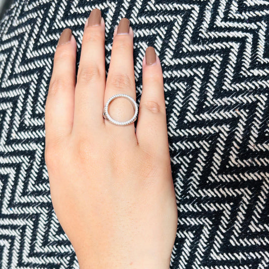 A circular sterling silver ring with pave stones.
