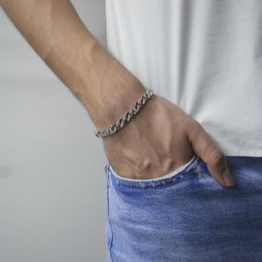 Close-up of a men's hand wearing a Glacier Link Bracelet in 925 sterling silver with diamond-cut stones, paired with casual denim and white tee.