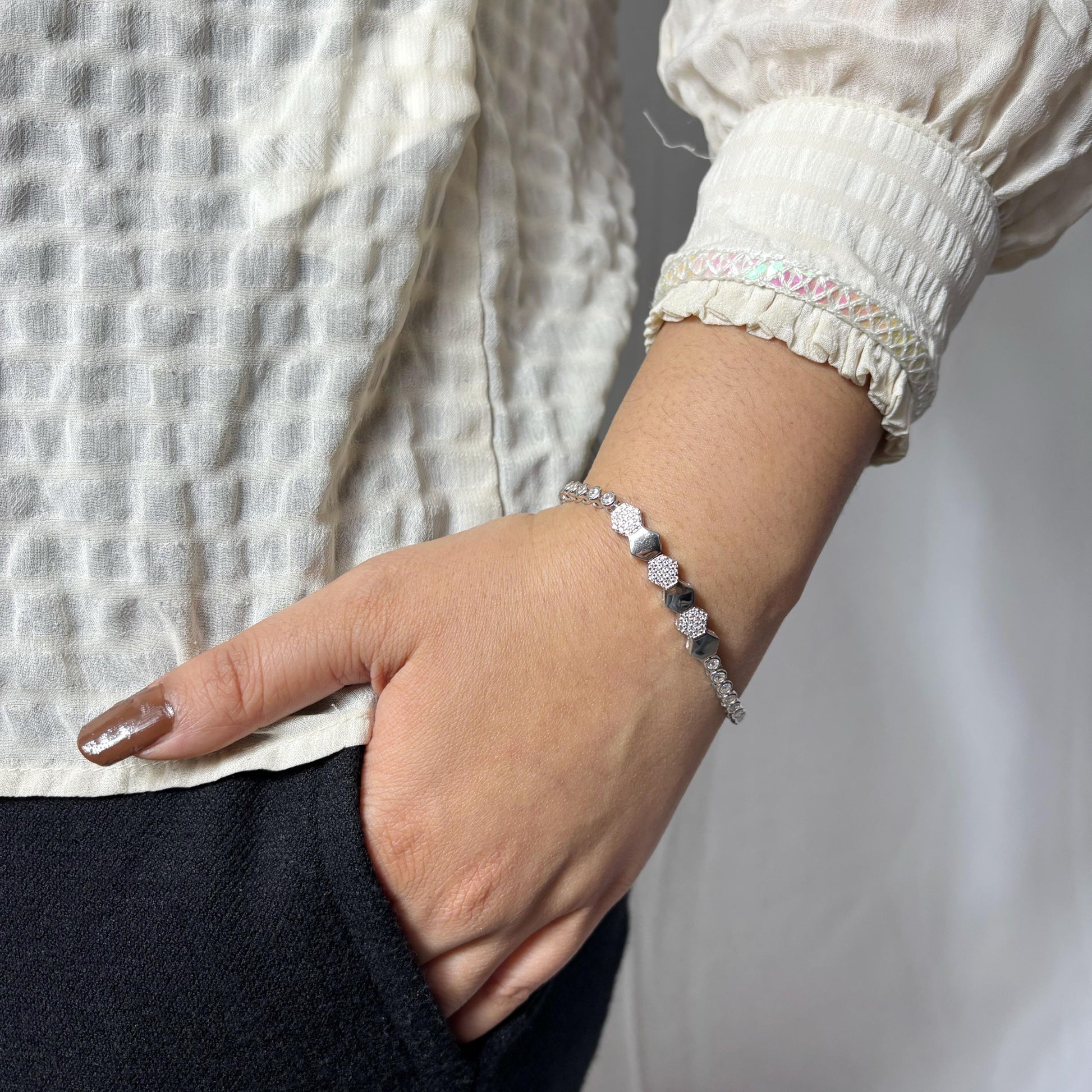 A stylish 925 sterling silver bracelet featuring alternating hexagon-shaped beads with polished and textured finishes, worn on a woman’s wrist.