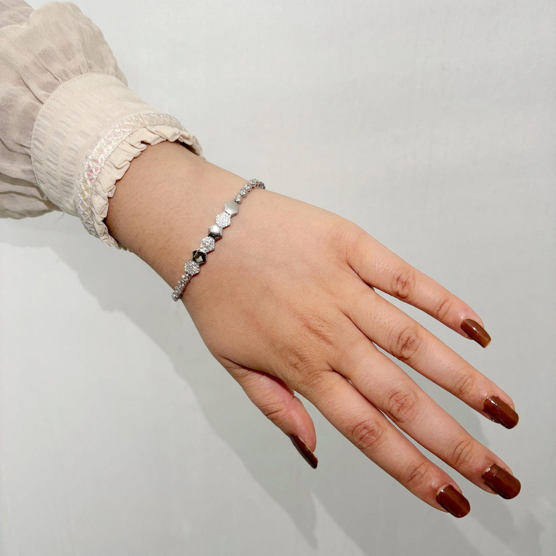 A stylish 925 sterling silver bracelet featuring alternating hexagon-shaped beads with polished and textured finishes, worn on a woman’s wrist.