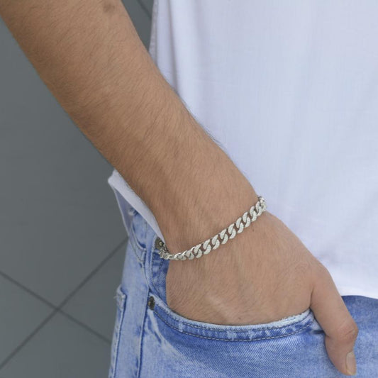 Men’s 925 silver Cuban link bracelet with pavé-set zircon stones, styled with a white shirt and denim jeans.