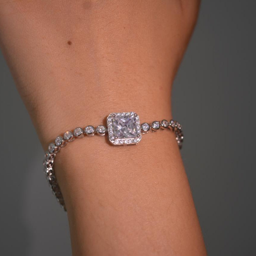 Close-up of a 925 sterling silver bracelet with a large square-cut solitaire center stone and bezel-set round zircon accents.