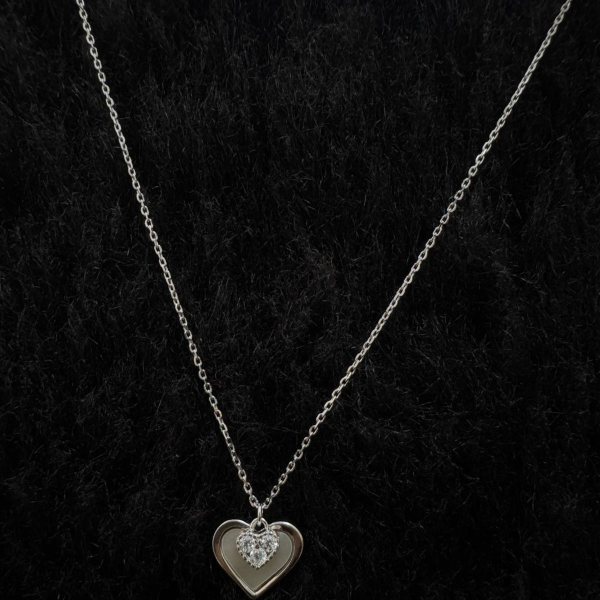 925 sterling silver necklace with a dual-heart pendant, featuring a polished heart and a sparkling pavé cubic zirconia heart