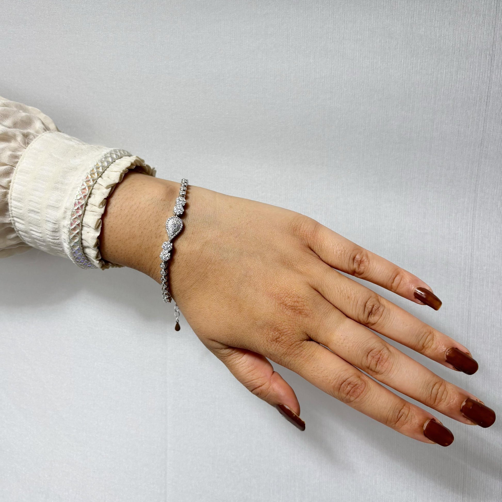 925 sterling silver bracelet featuring a central teardrop-shaped CZ stone cluster, worn on a woman's wrist with a neutral outfit.