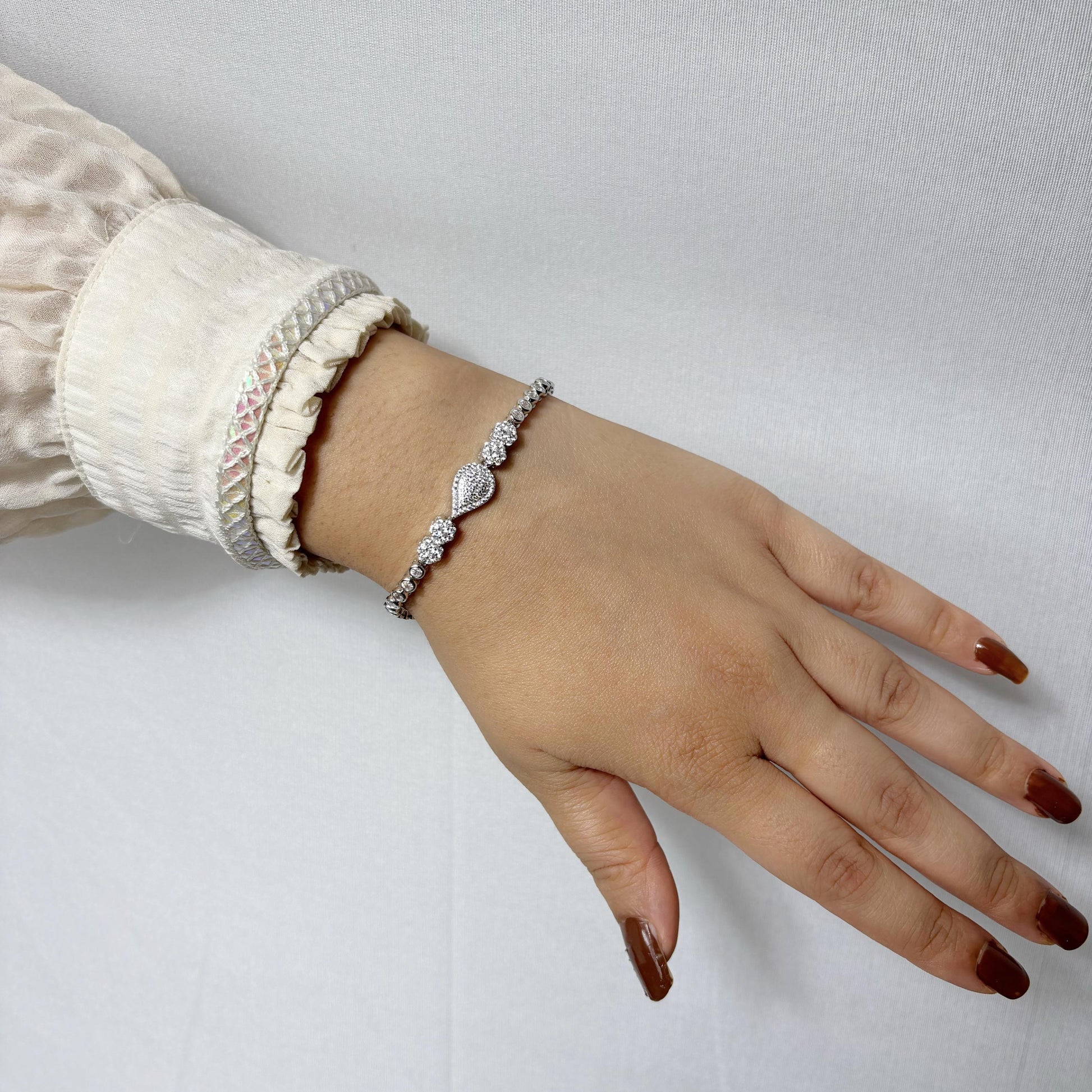 925 sterling silver bracelet featuring a central teardrop-shaped CZ stone cluster, worn on a woman's wrist with a neutral outfit.