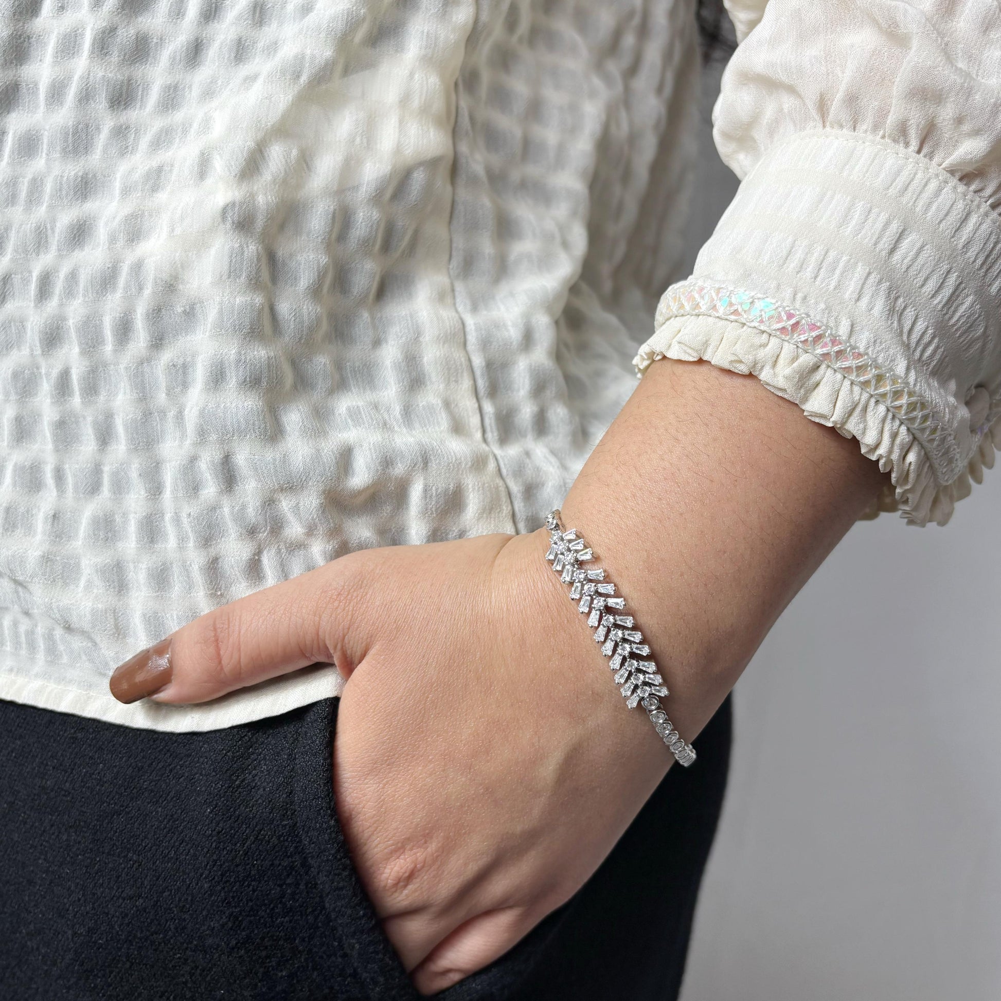 925 sterling silver bracelet with a graceful vine-like design and marquise-cut CZ stones, elegantly worn on a woman's wrist.