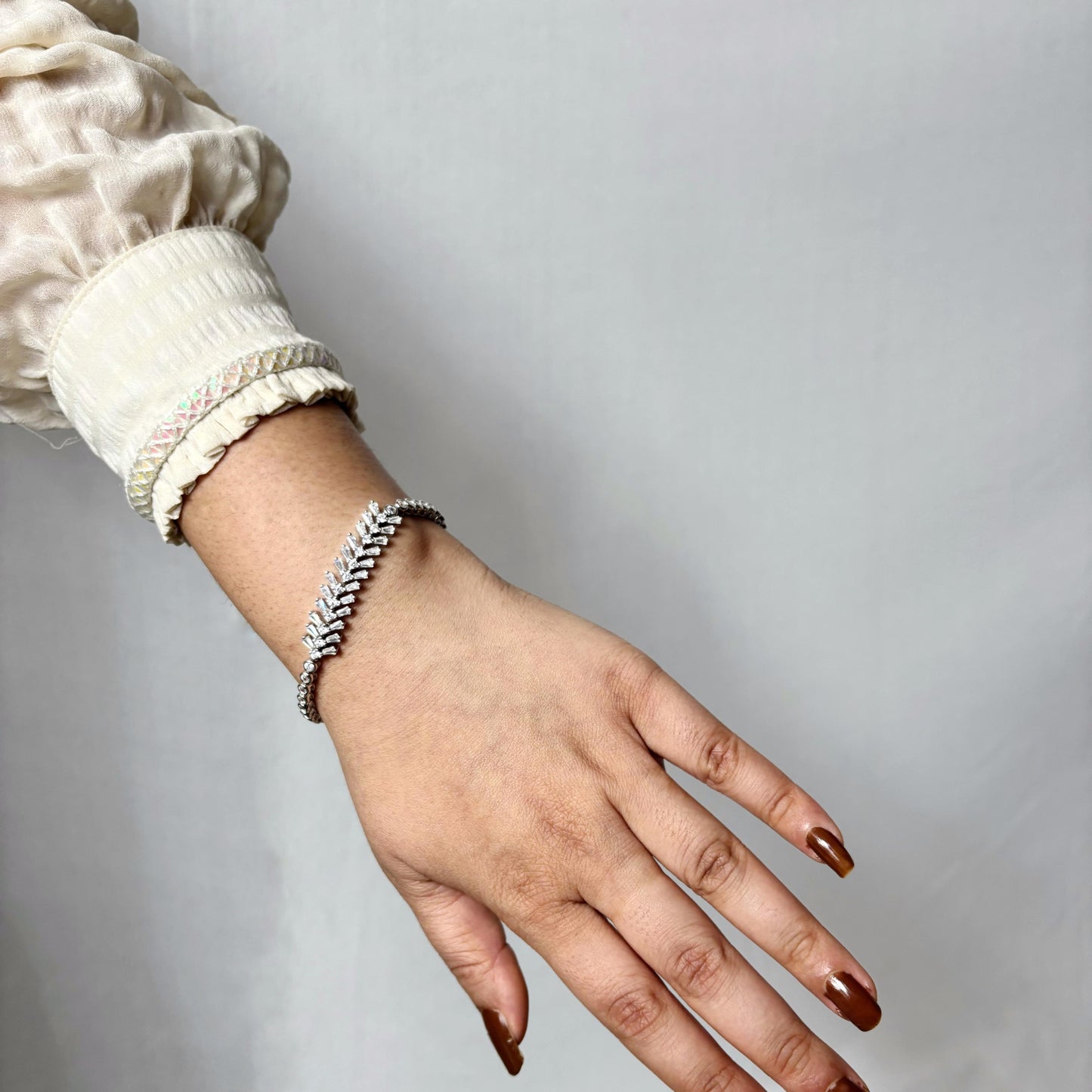 925 sterling silver bracelet with a graceful vine-like design and marquise-cut CZ stones, elegantly worn on a woman's wrist.