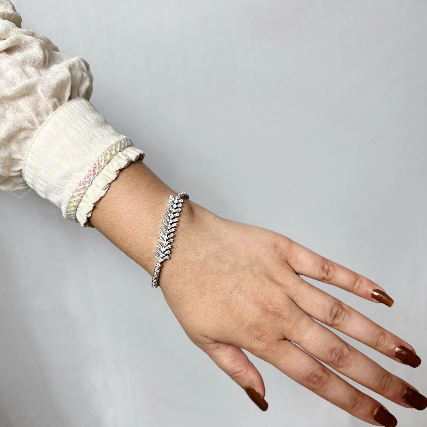 925 sterling silver bracelet with a graceful vine-like design and marquise-cut CZ stones, elegantly worn on a woman's wrist.