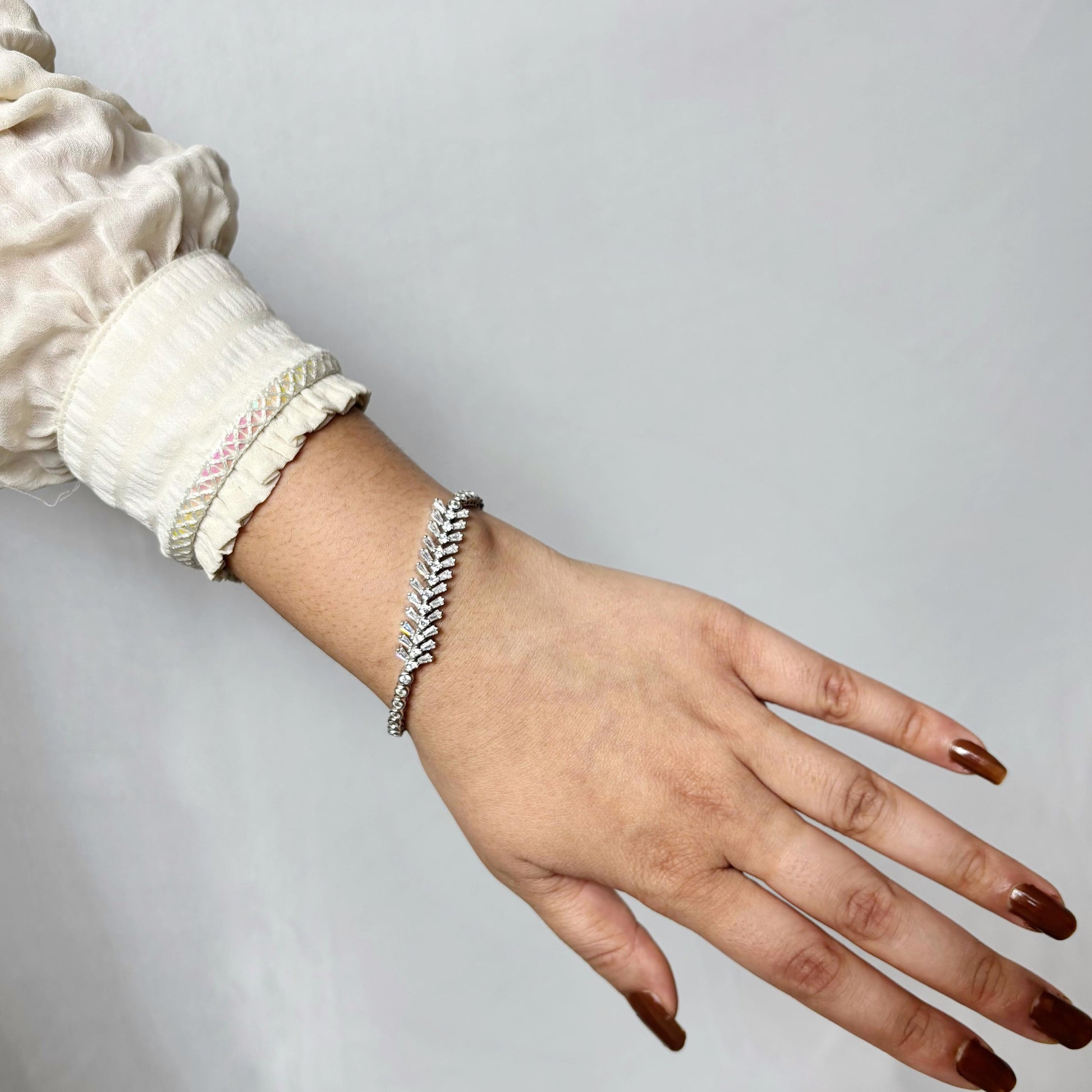 925 sterling silver bracelet with a graceful vine-like design and marquise-cut CZ stones, elegantly worn on a woman's wrist.